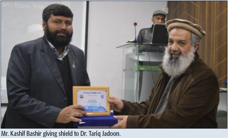 Mr. Kashif Bashir giving shield to Dr. Tariq Jadoon.