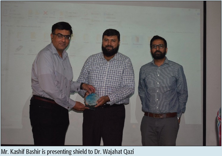 Mr. Kashif Bashir is presenting shield to Dr. Wajahat Qazi